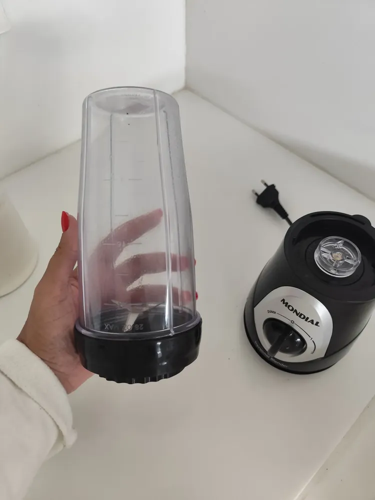 Compradora mostrando o copo e a base do Personal Blender Mondial